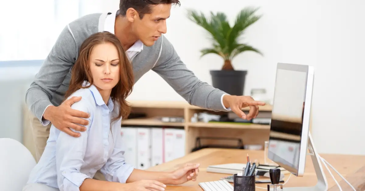 Male worker putting arm around female worker