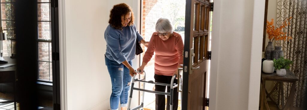 Older woman with walker entering a doorway.