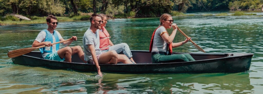 A group of people paddle through water.