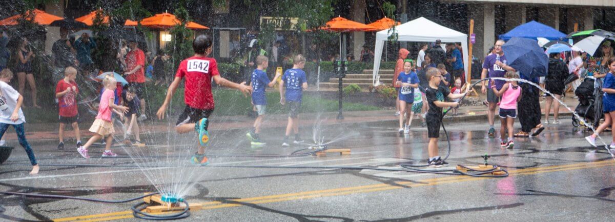 kids playing by sprinklers
