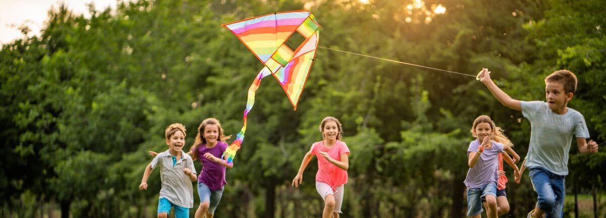 kids in field flying kite