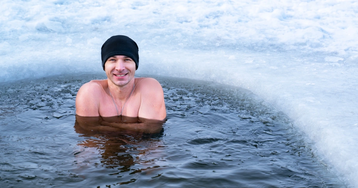 Man in a pool during the winter time with a beanie on.